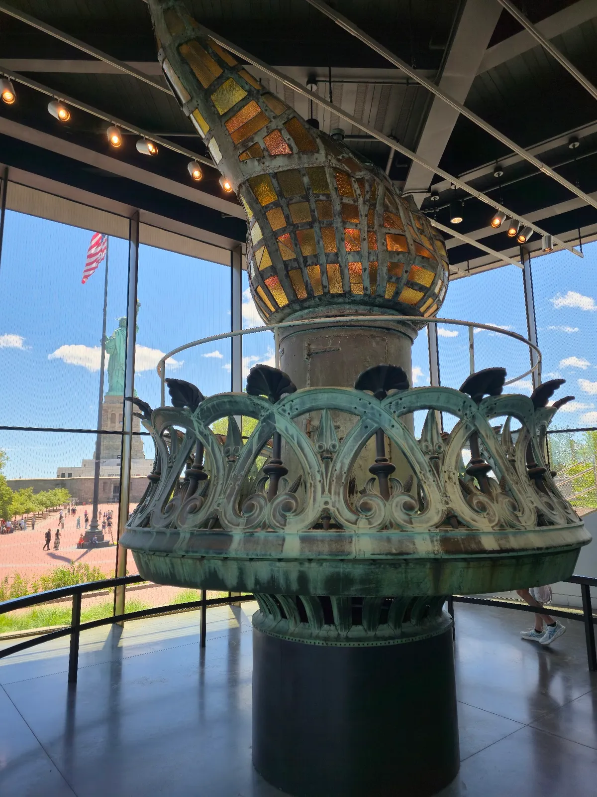 Original torch inside museum, statue visible outside