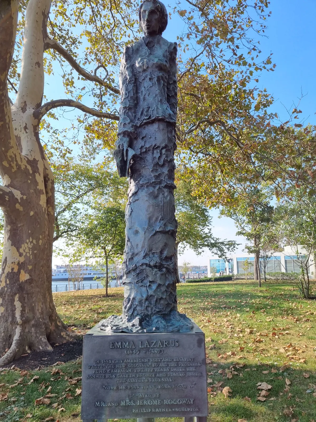 Emma Lazarus bronze statue beneath autumn trees