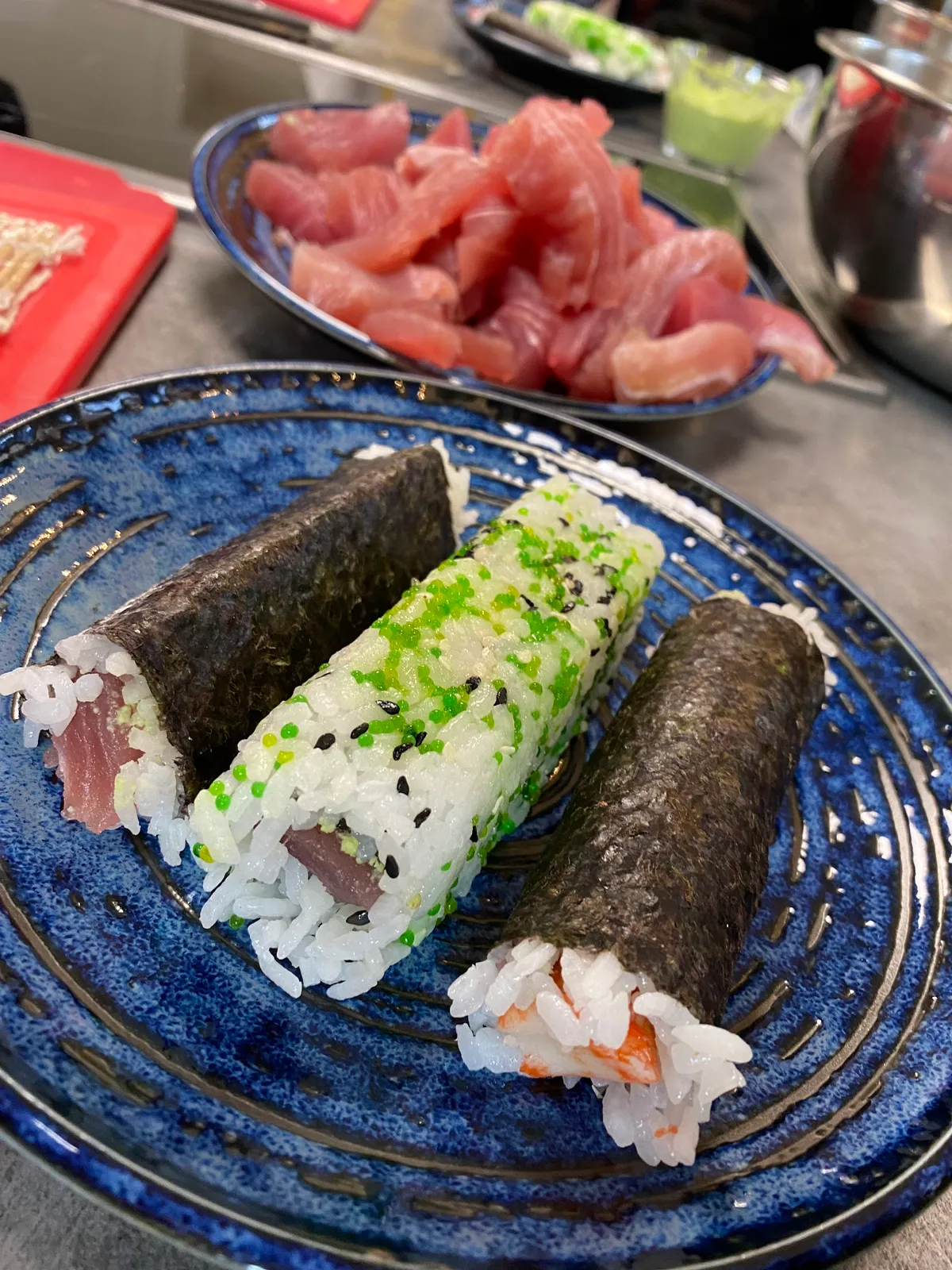 Čerstvě připravené sushi rolky na modrém talíři.
