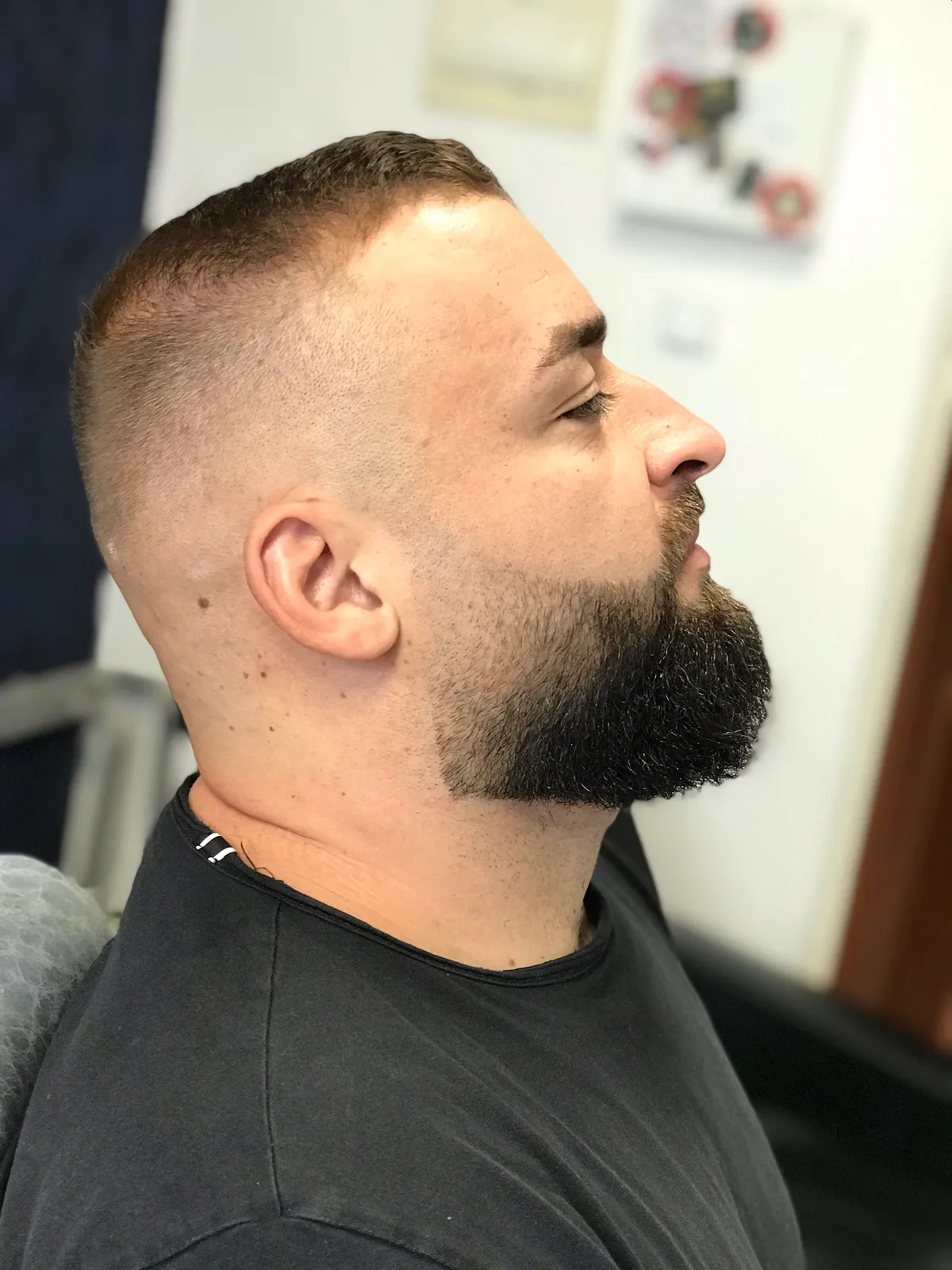 Moderní střih vlasů a upravená bradka z profilu.
