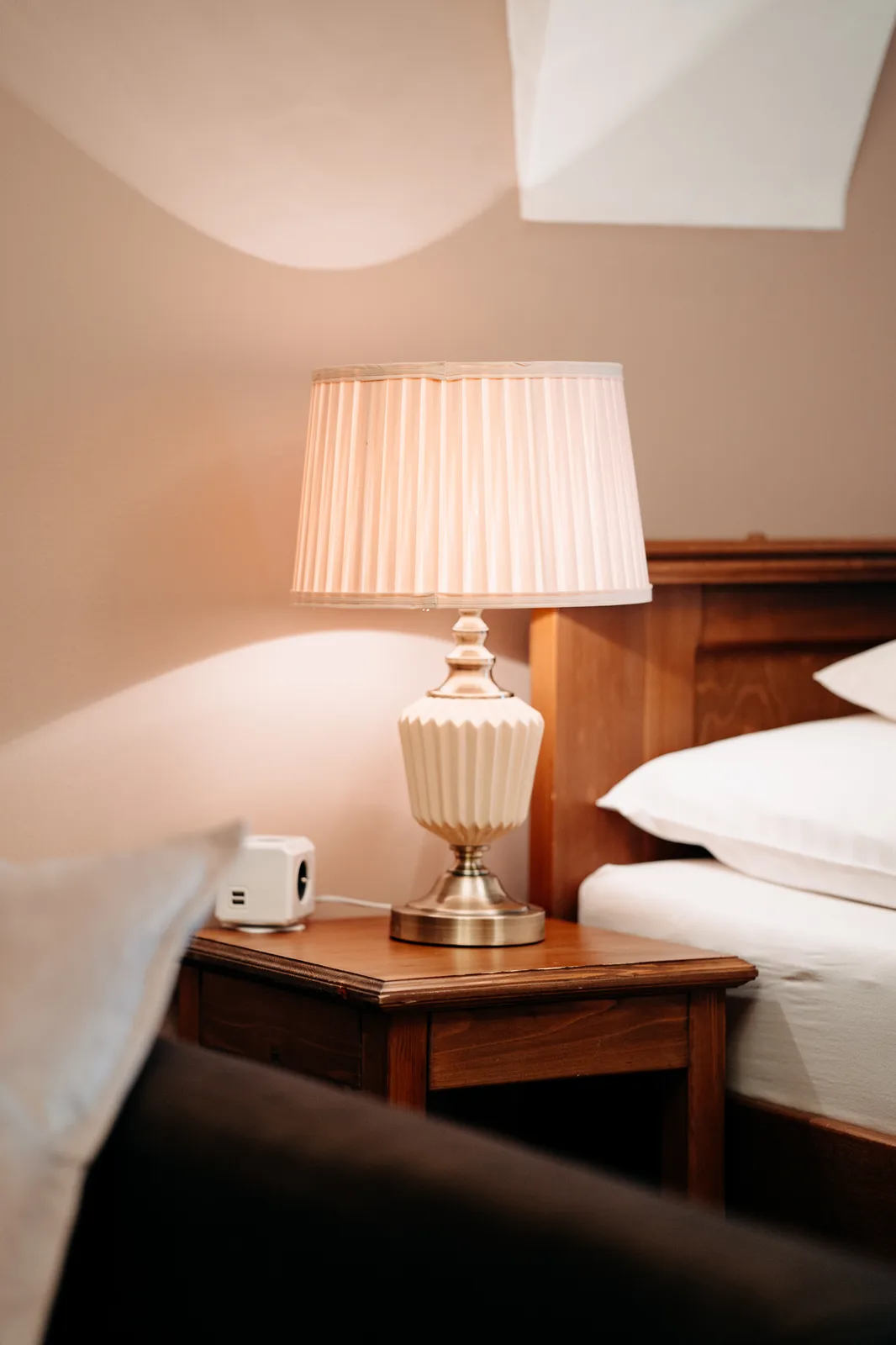 Příjemné světlo lampy na nočním stolku ložnice