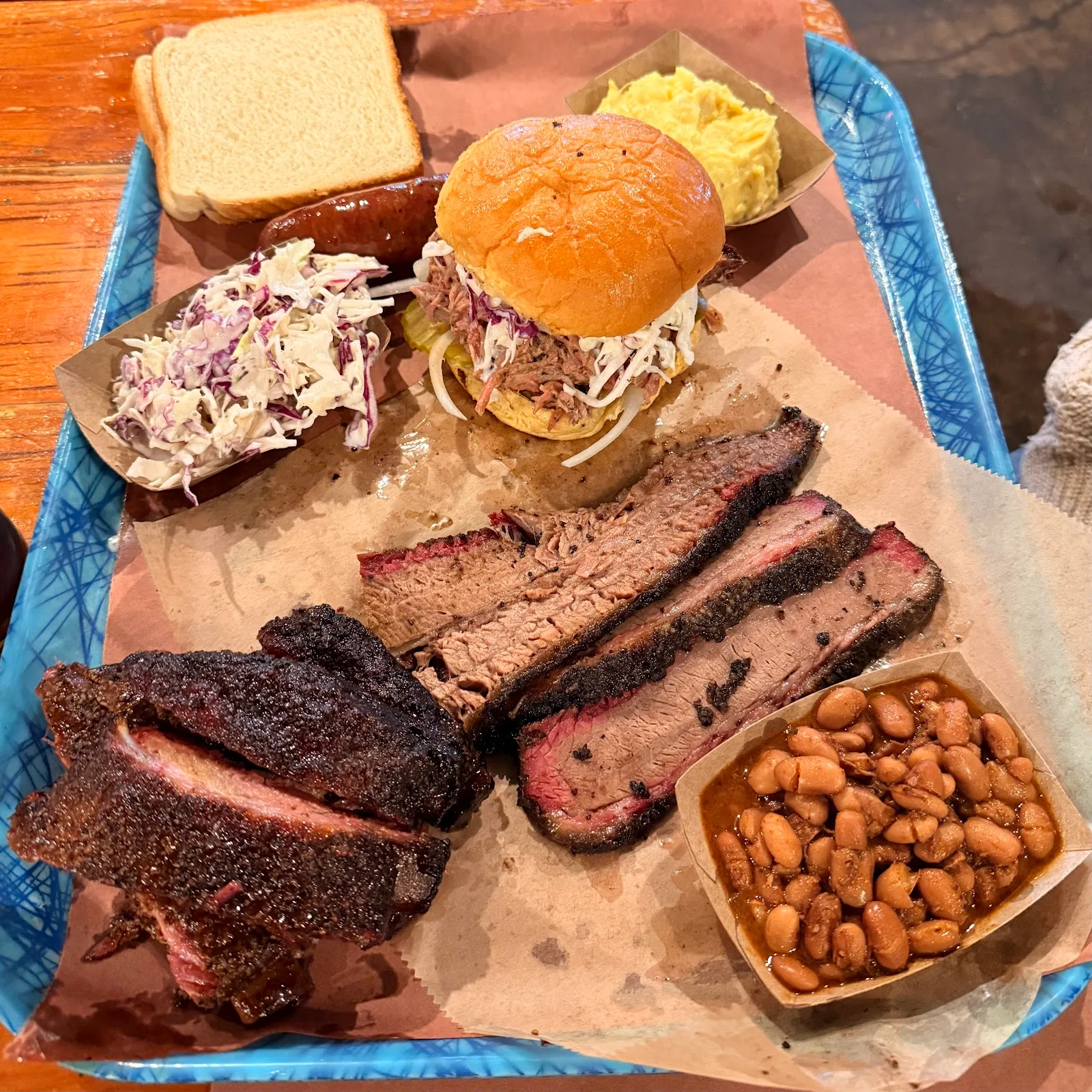 Abundant barbecue platter: brisket, ribs, sandwich, sides.