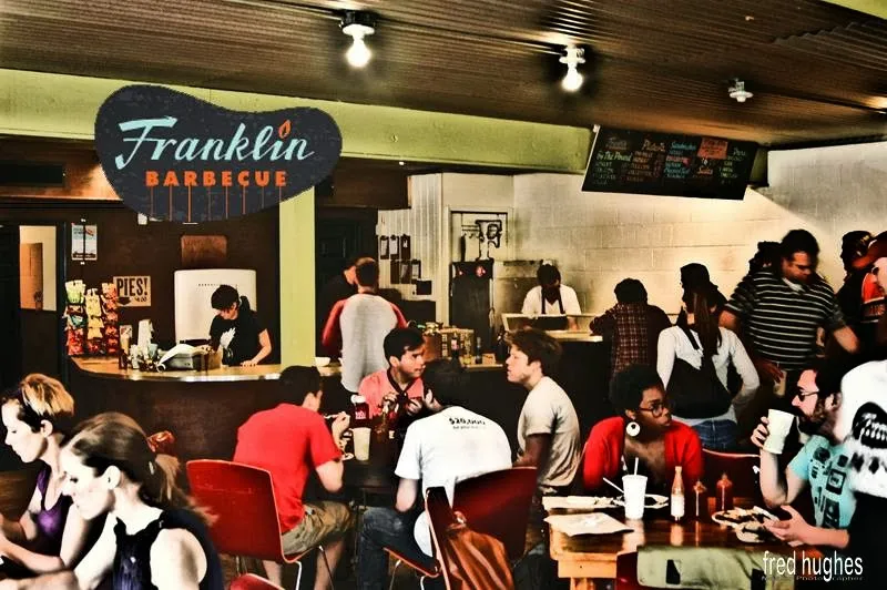 Lively Franklin Barbecue restaurant interior, bustling with guests.