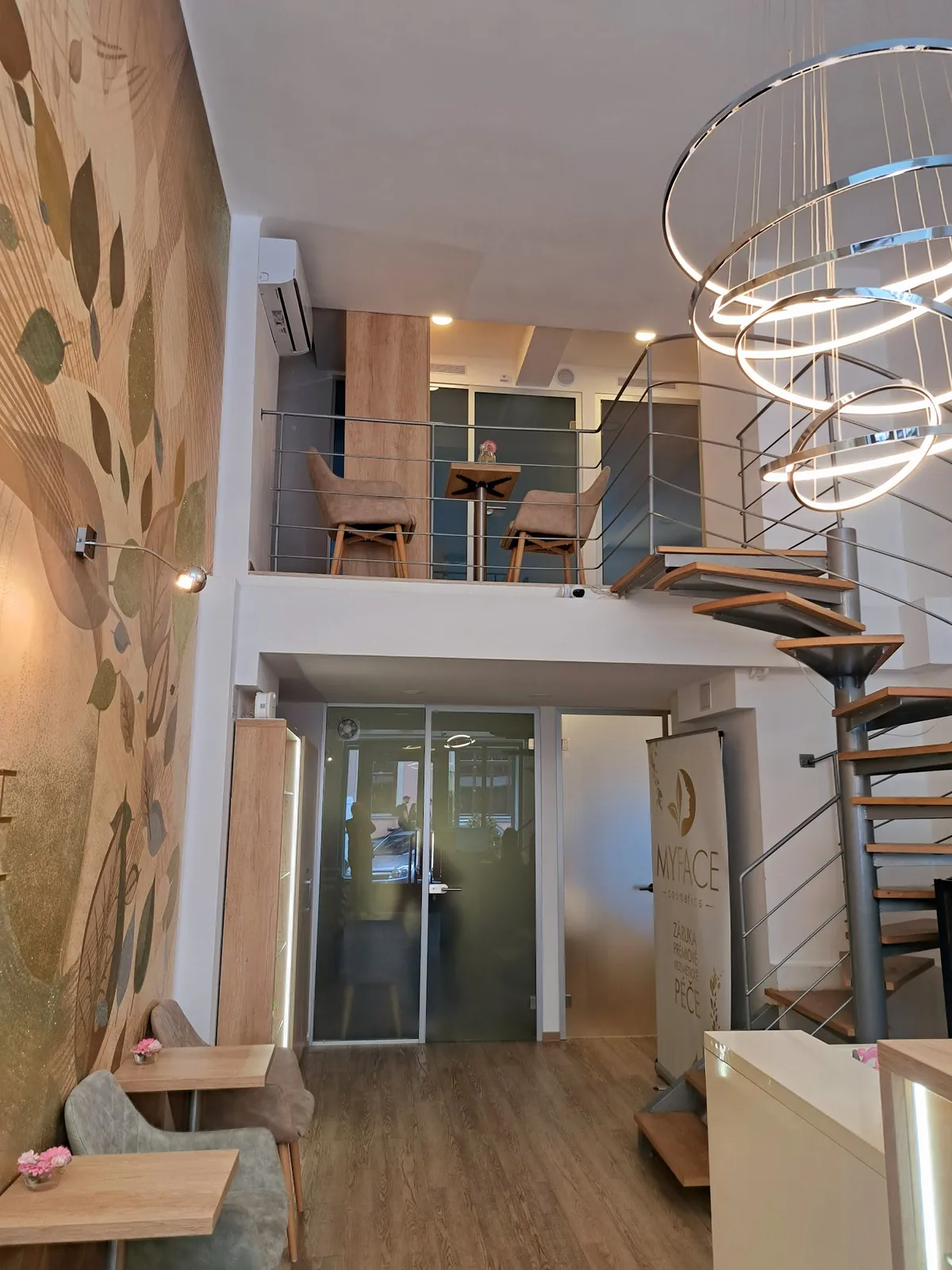 Elegantní interiér salonu s moderním schodištěm.