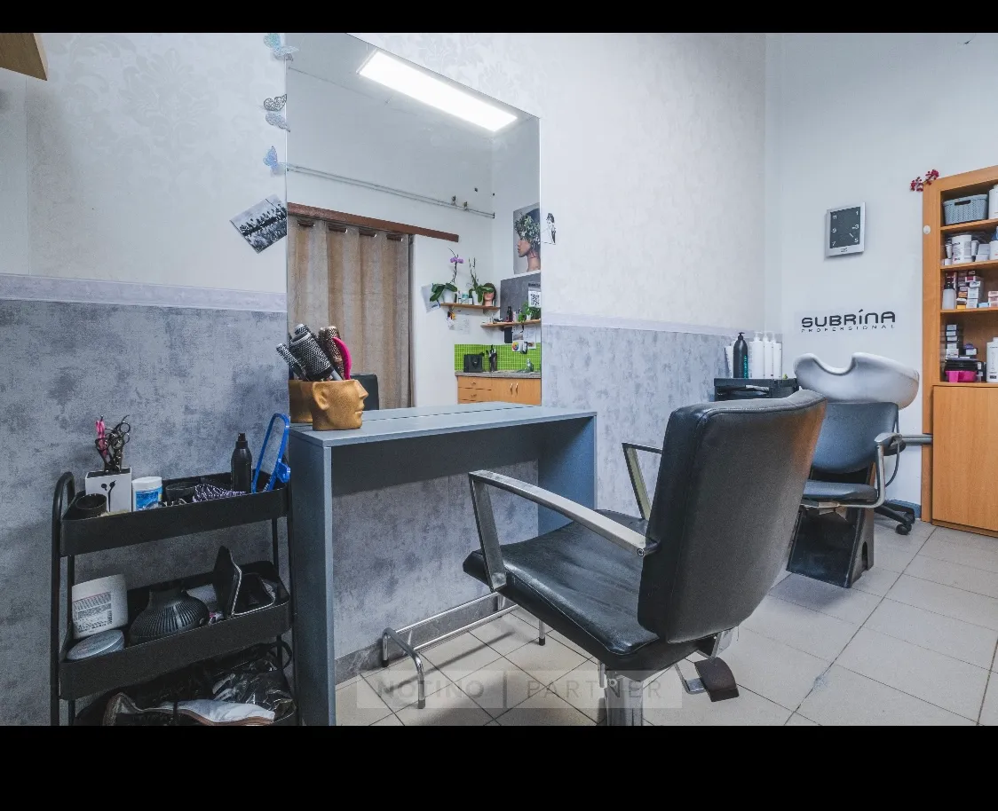 Moderní a útulný interiér kadeřnictví s křeslem.