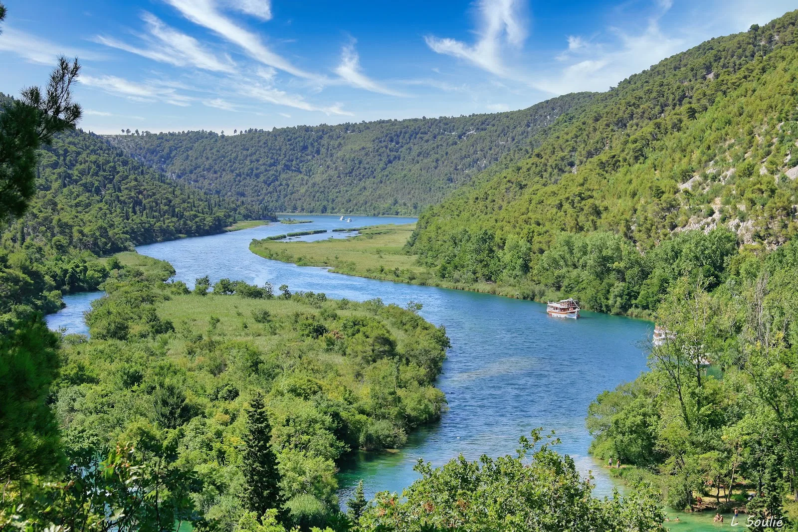Winding blue river through a forested valley