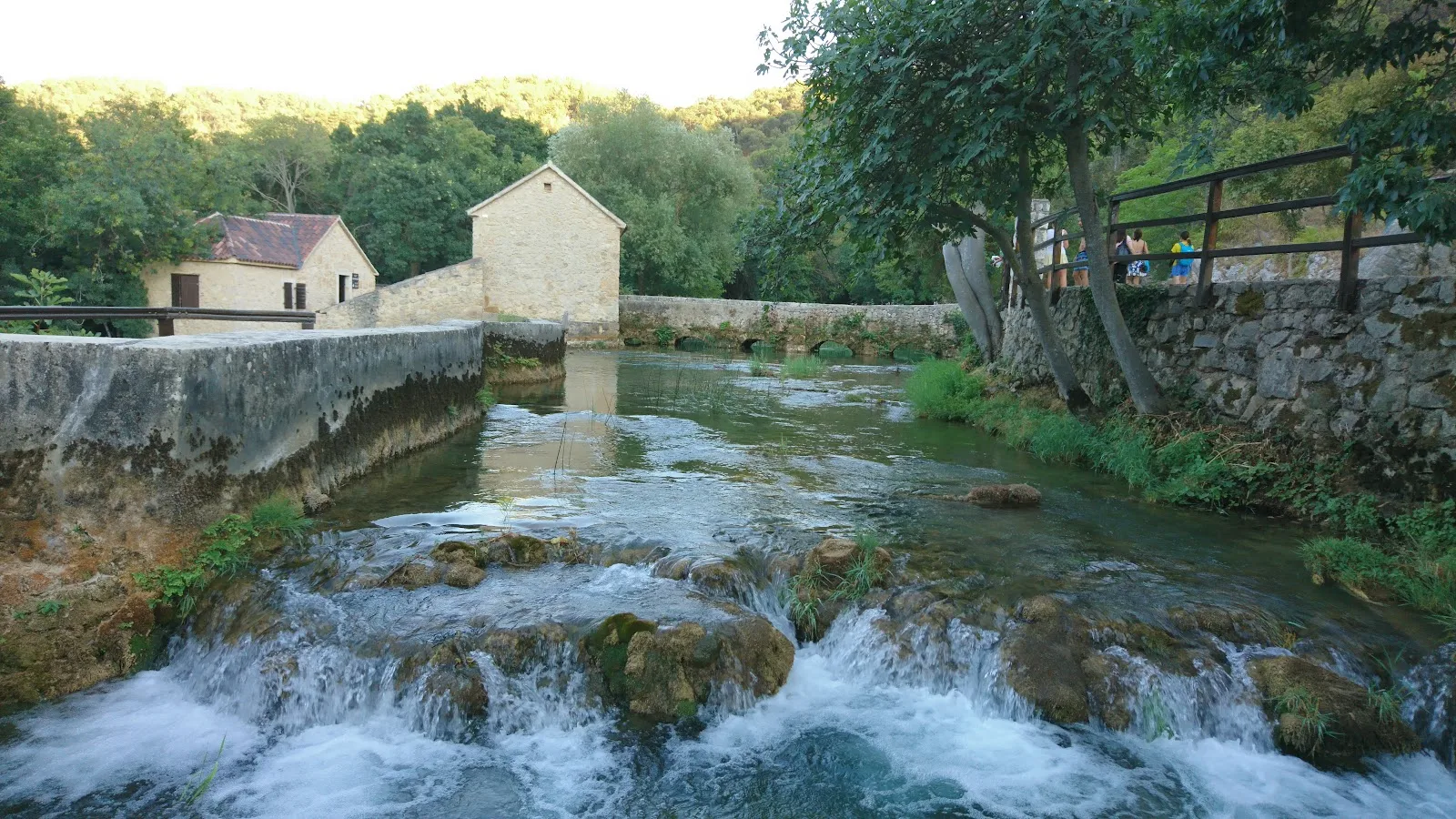 Historic stone mills beside Krka's flowing river.