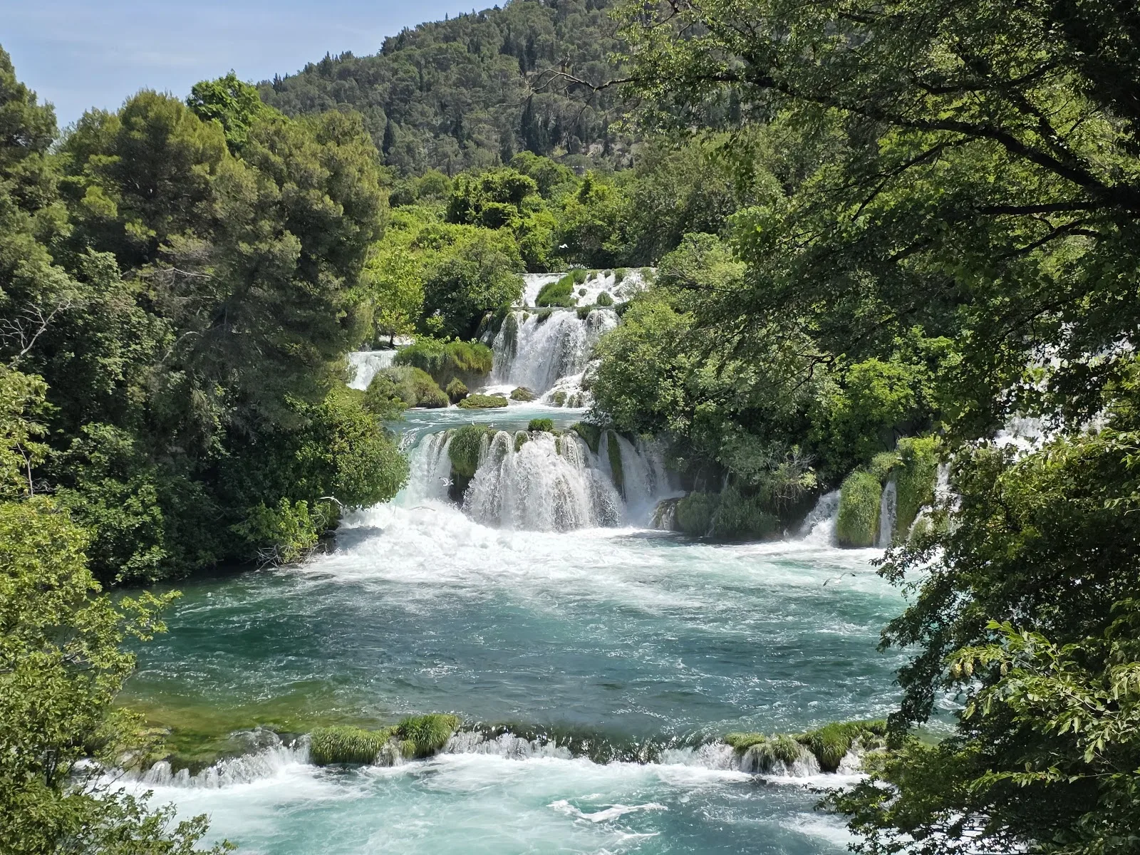 Foaming waterfalls cascade through verdant foliage