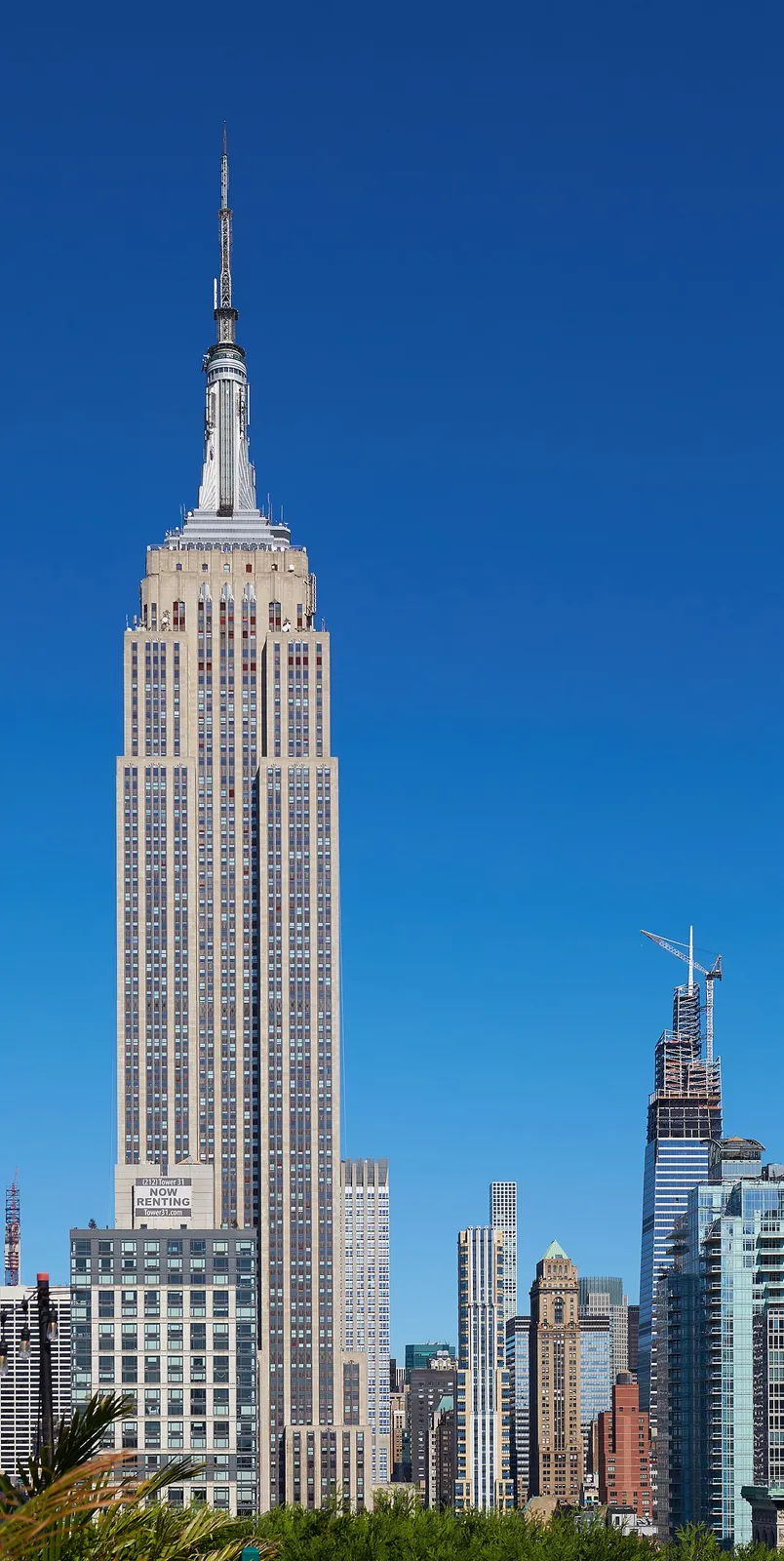 Iconic Art Deco spire against brilliant blue sky.