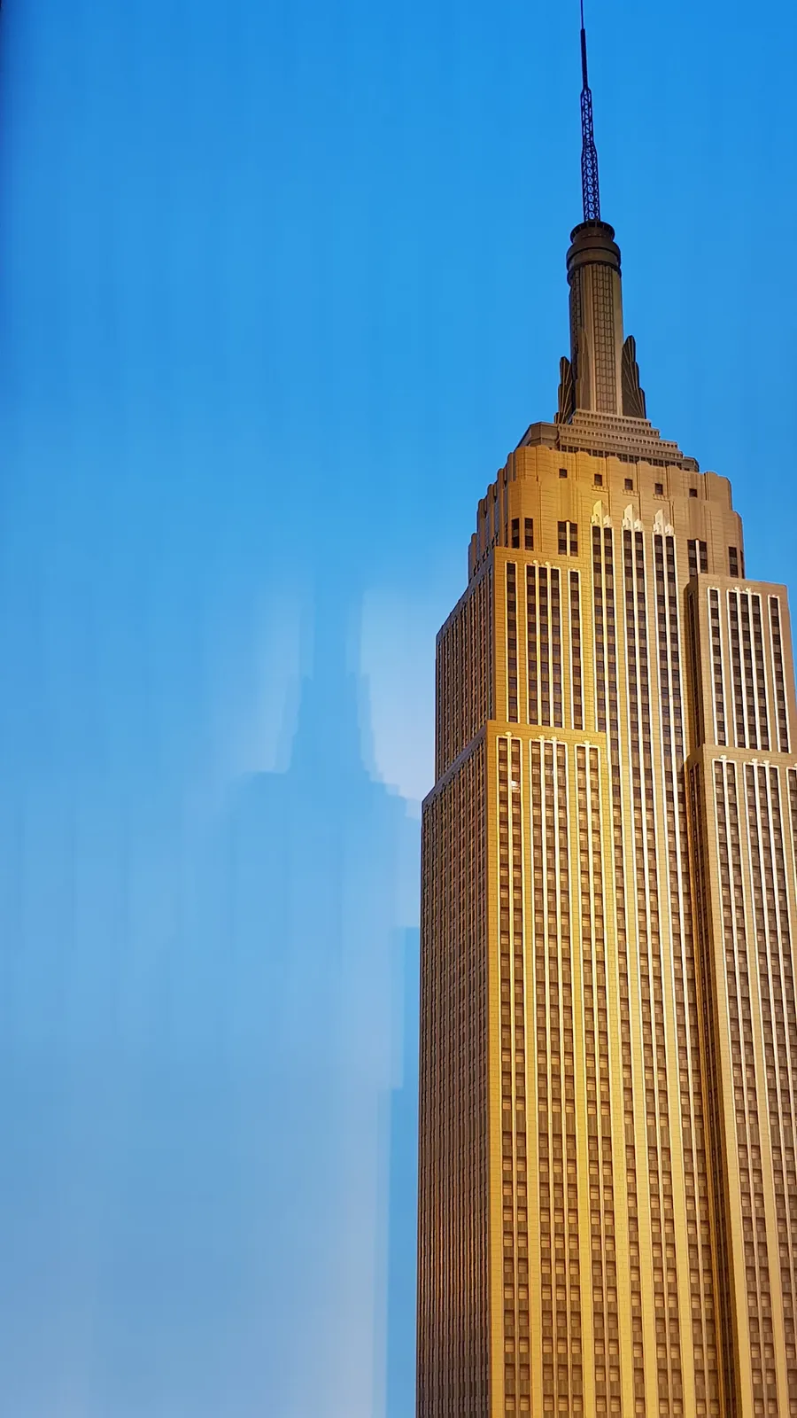 Golden Empire State Building against a clear blue sky