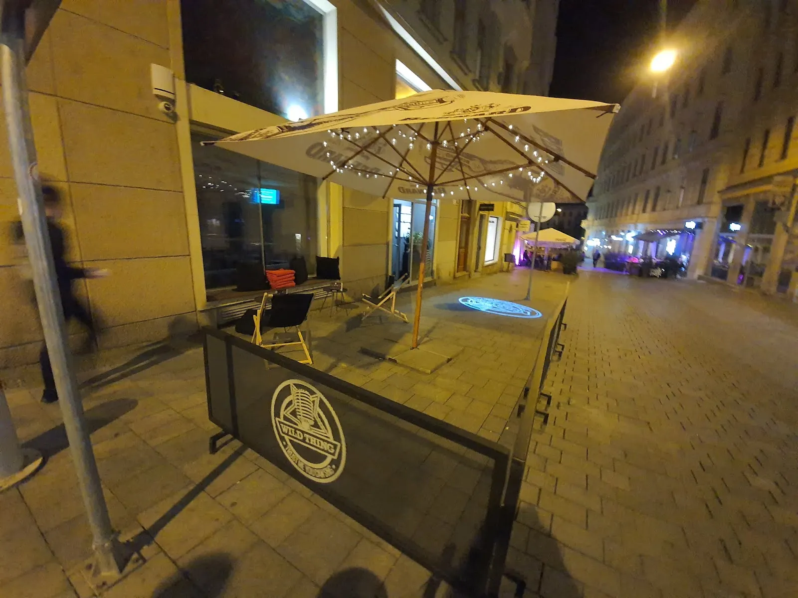 Osvětlená terasa Wild Thing Brno láká k noční zábavě.
