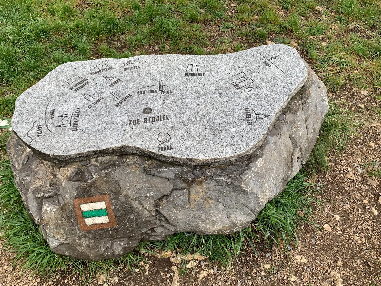 Kamenná mapa s vyznačenými body a turistickou značkou.