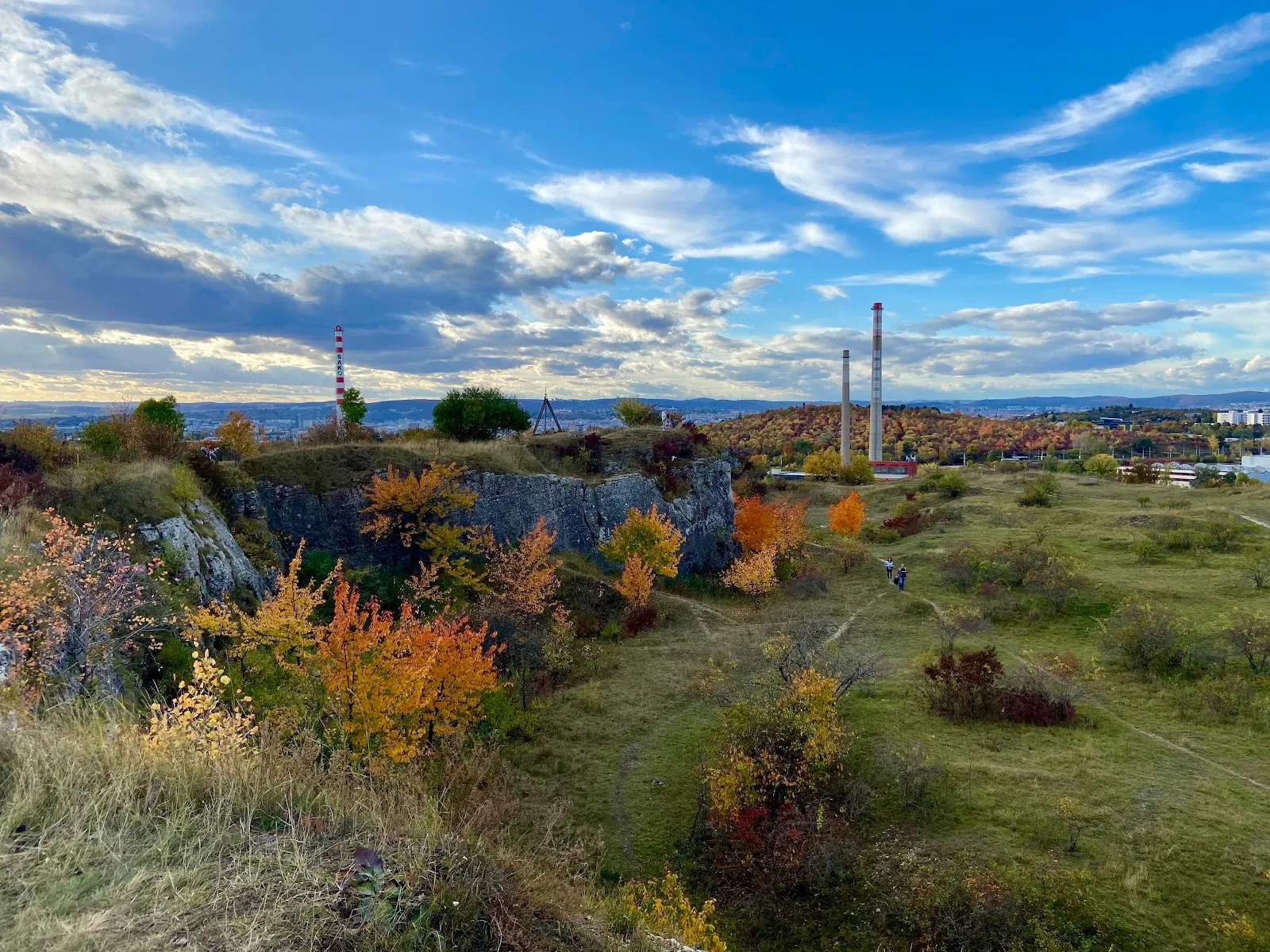 Podzimní panorama Stránské skály s barevnými stromy a komíny.