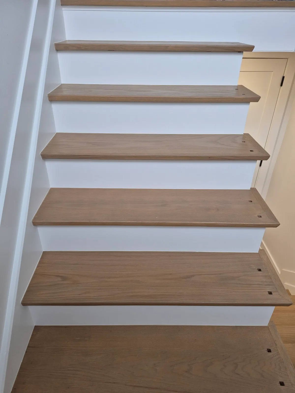 Newly painted white risers and wooden treads.
