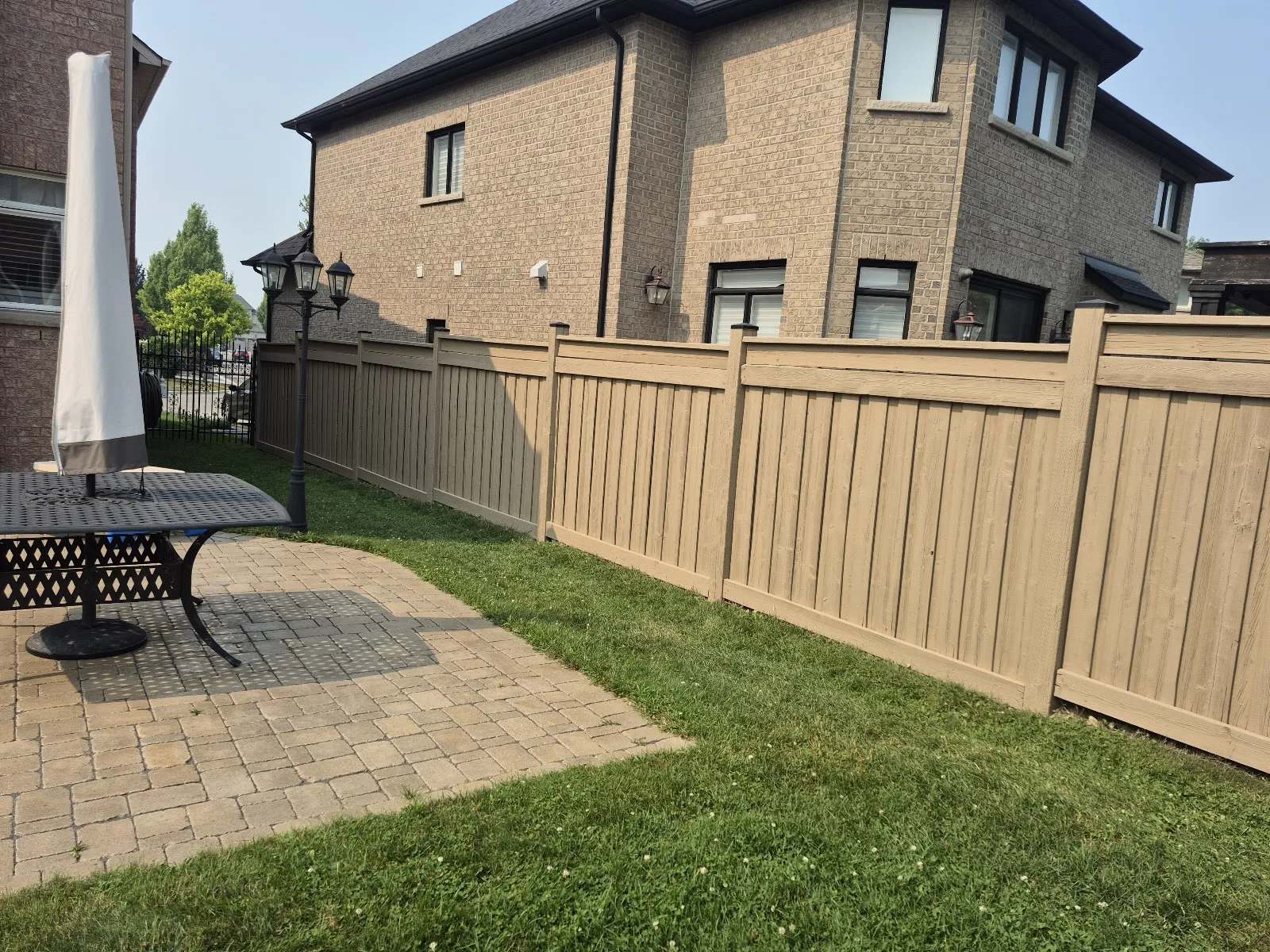 Freshly installed tan privacy fence in backyard.