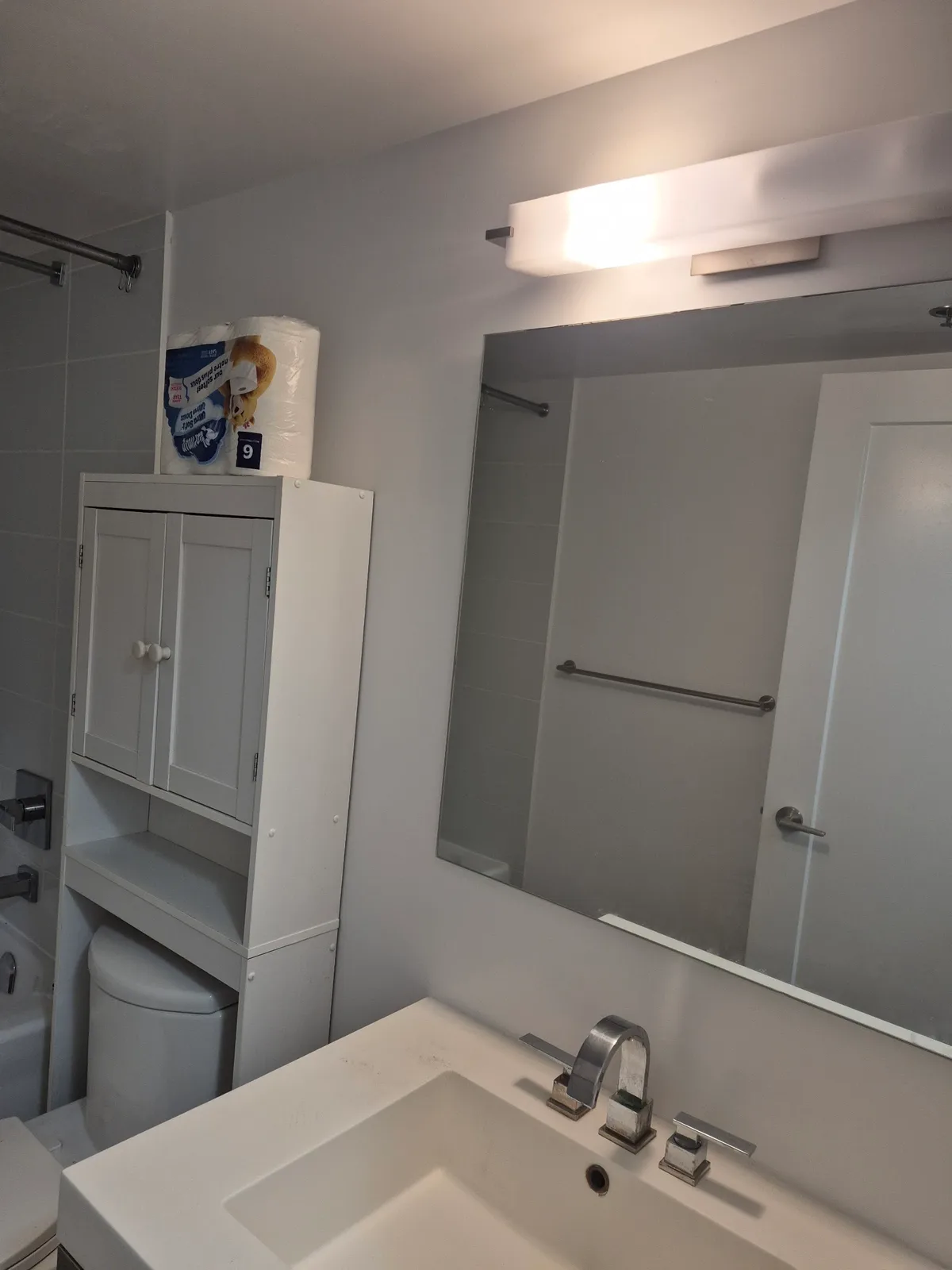 Bright modern bathroom with white vanity and mirror.
