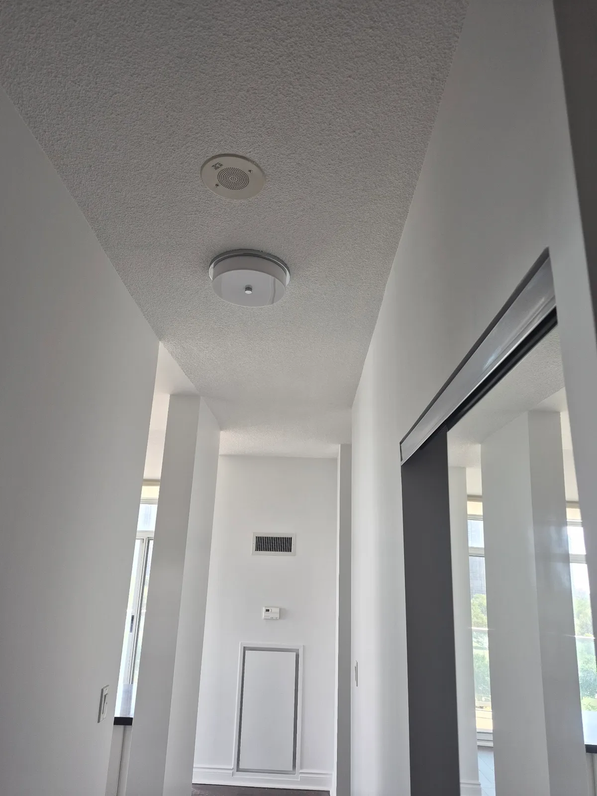 Bright white hallway with textured ceiling, clean finish