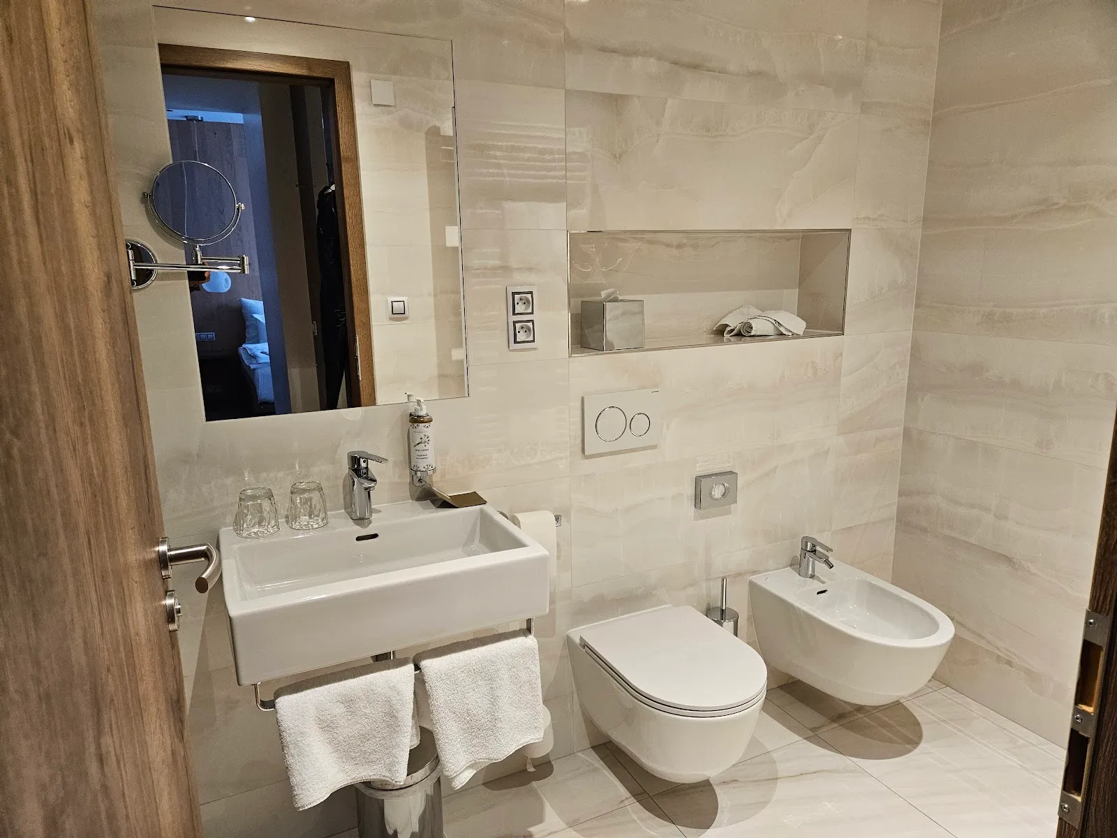 Elegantní koupelna s mramorovými obklady a moderním vybavením.