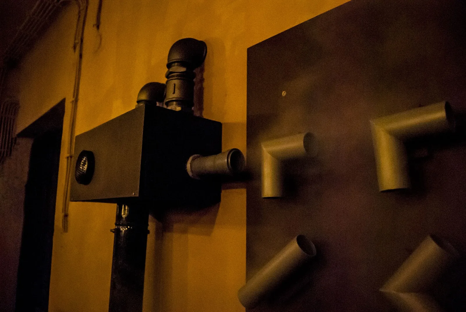 Detail steampunkového hlavolamu s potrubím na zdi