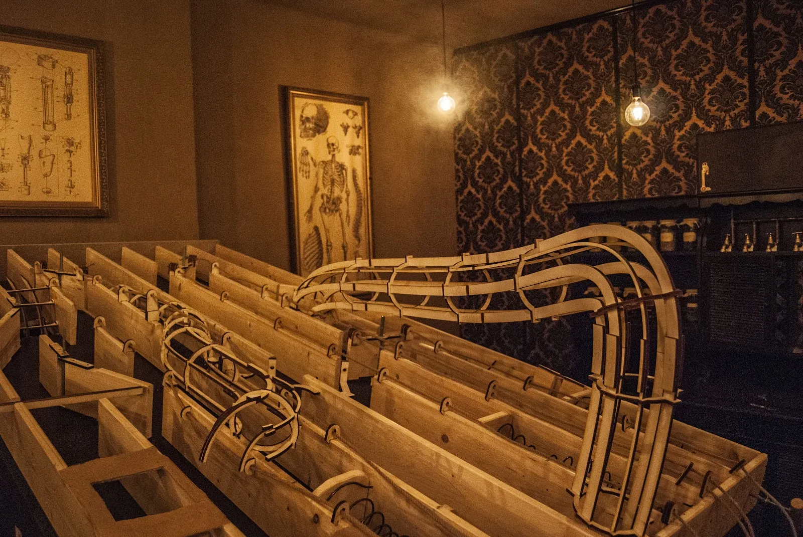 Složitý dřevěný mechanismus uprostřed tajemné laboratoře.