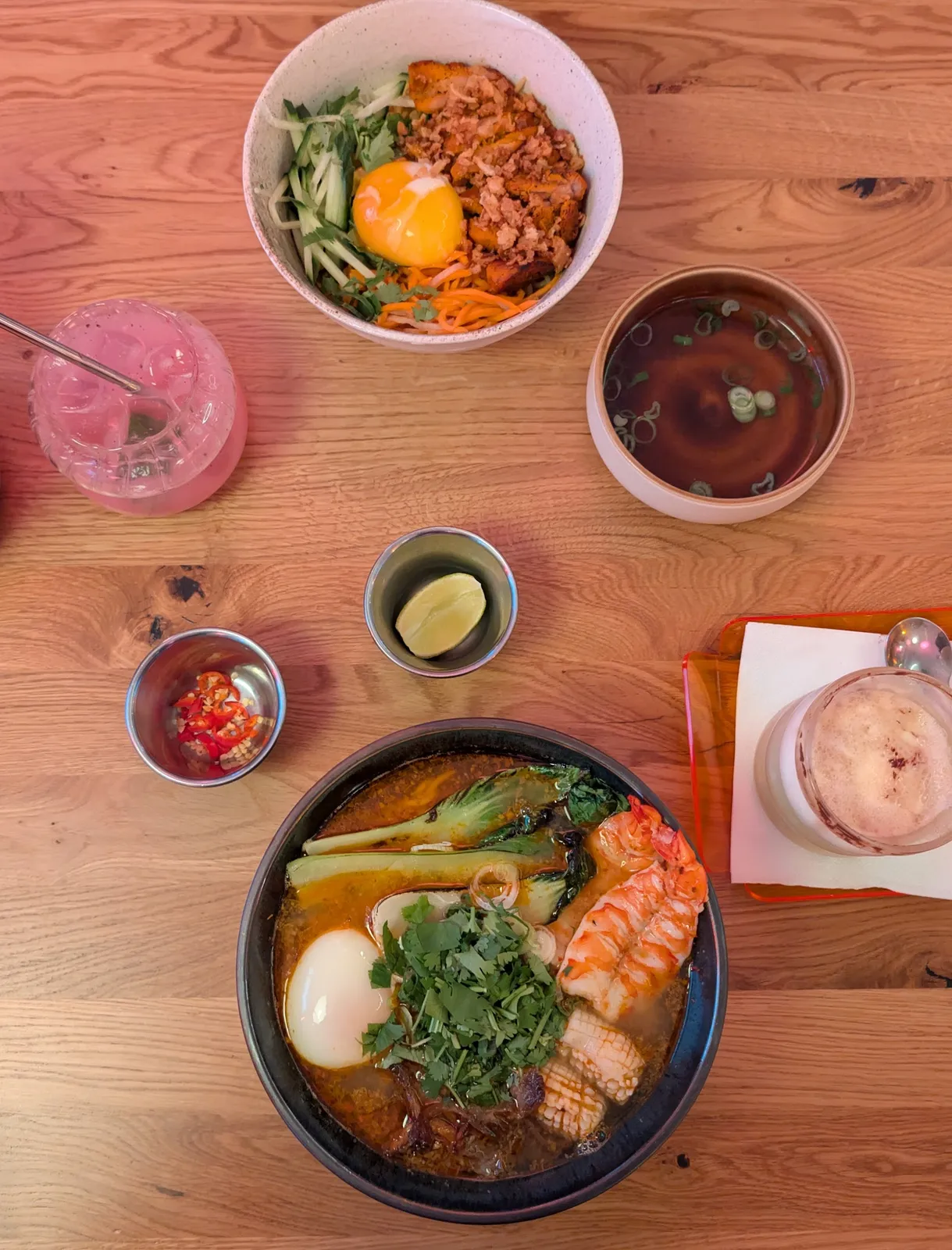 Bohatá ramen polévka, poke bowl a růžový koktejl.