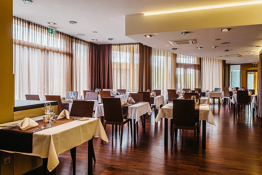 Prostorná restaurace hotelu Maximus Resort připravená k večeři.