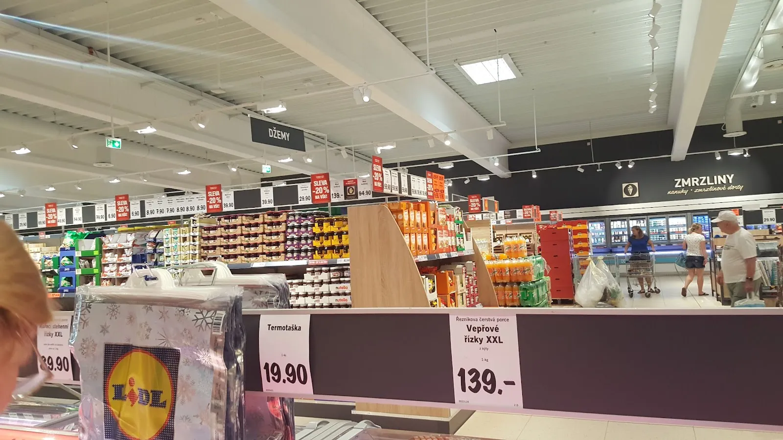 Široký záběr interiéru Lidl s regály plnými zboží.