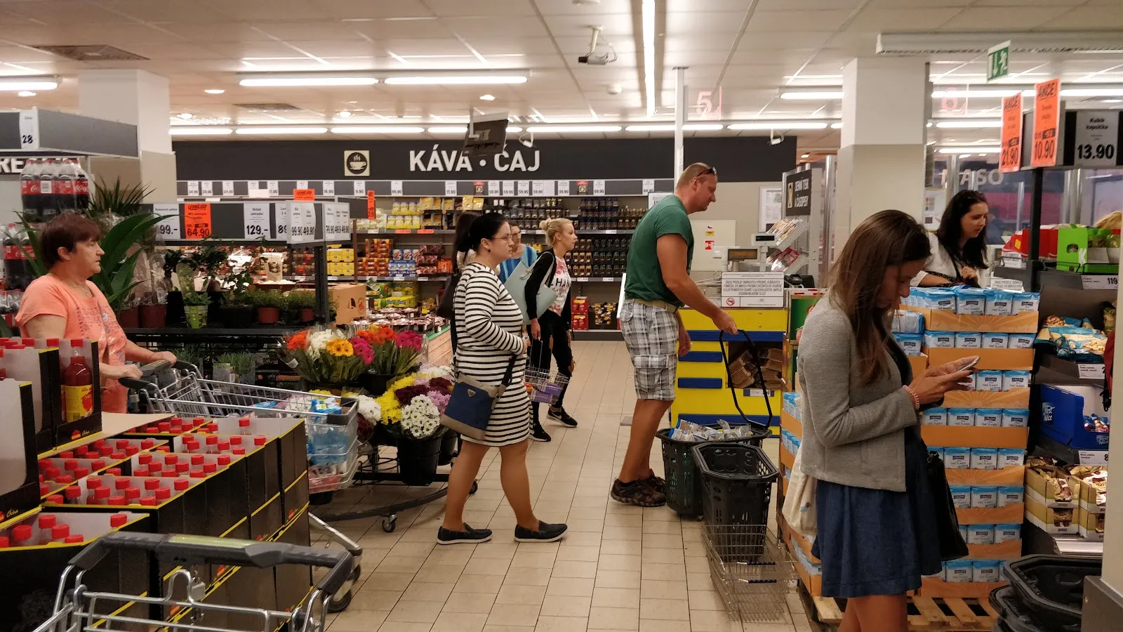 Zákazníci nakupují v uličce s kávou a čajem.