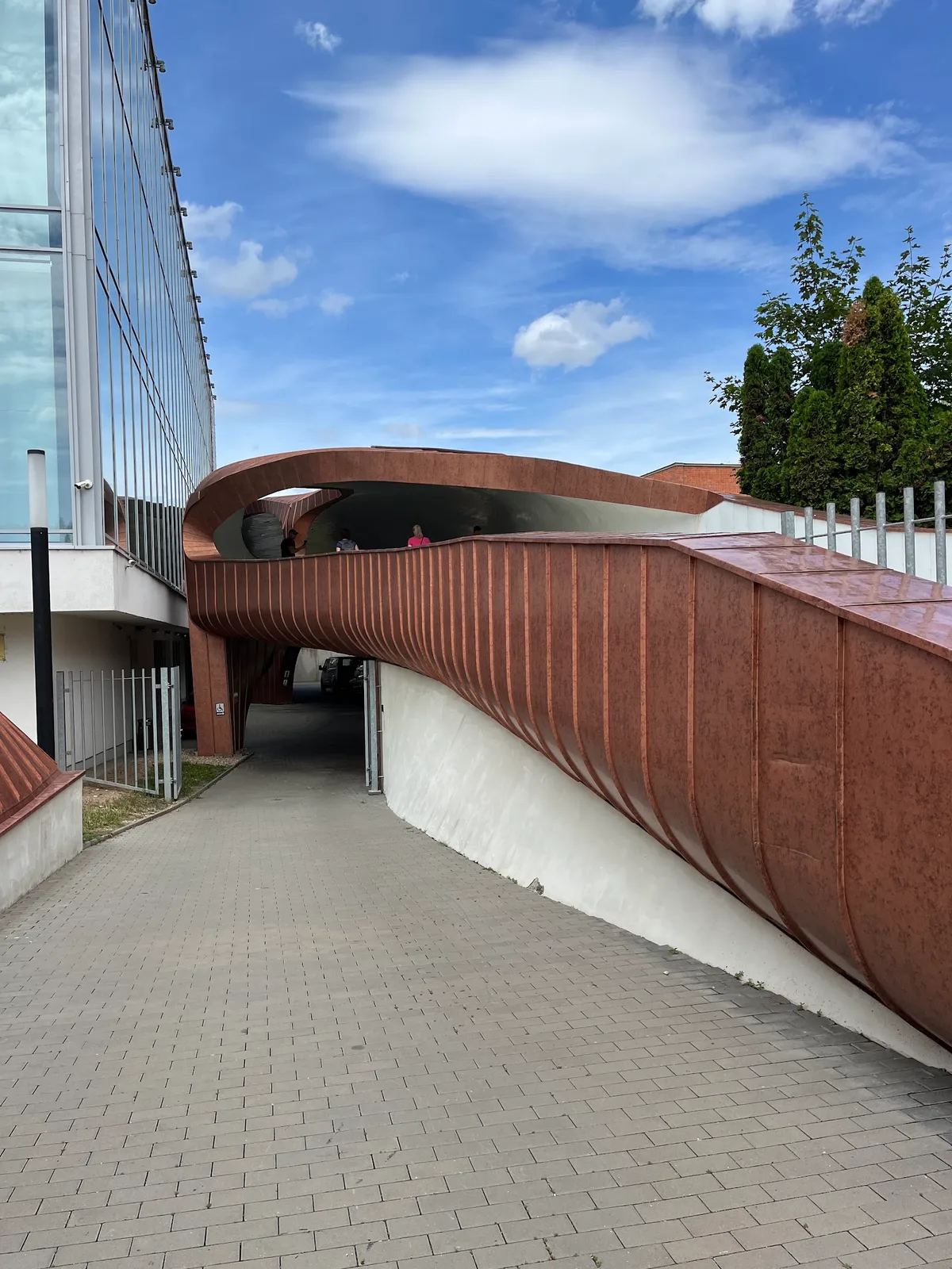Zakřivená měděná lávka u moderního centra