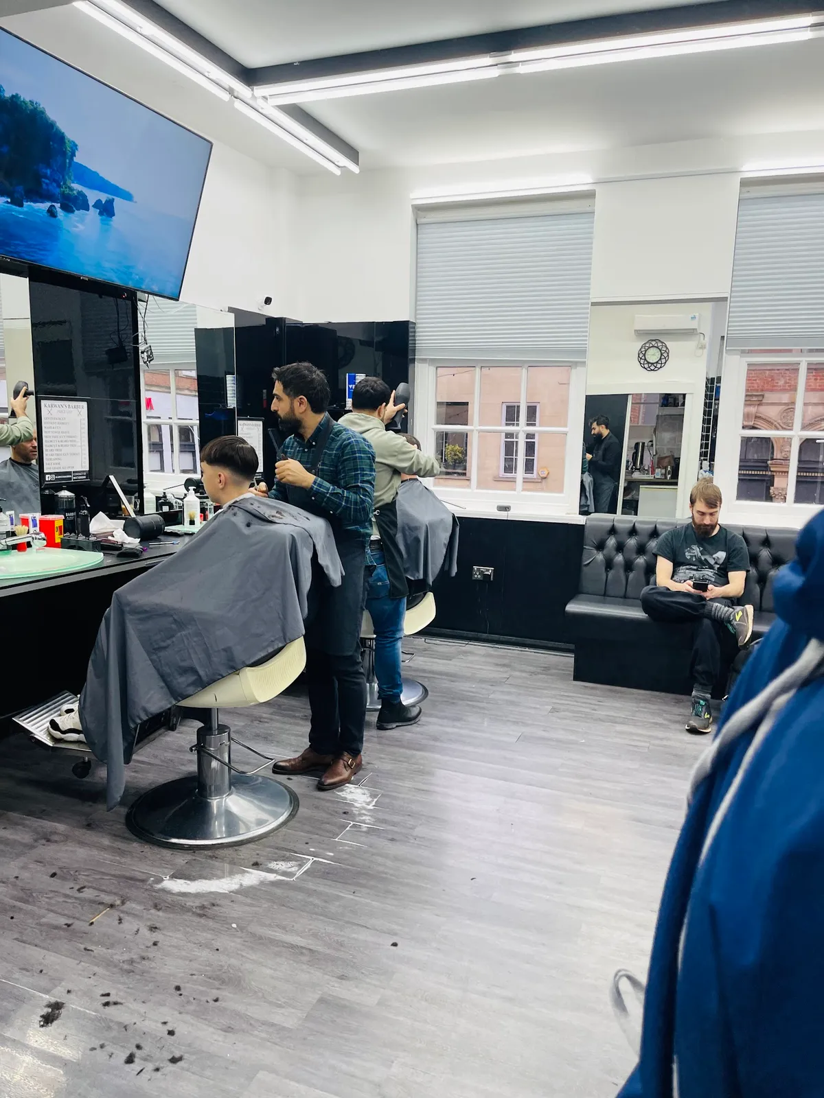 Focused barber meticulously crafting a fresh haircut.