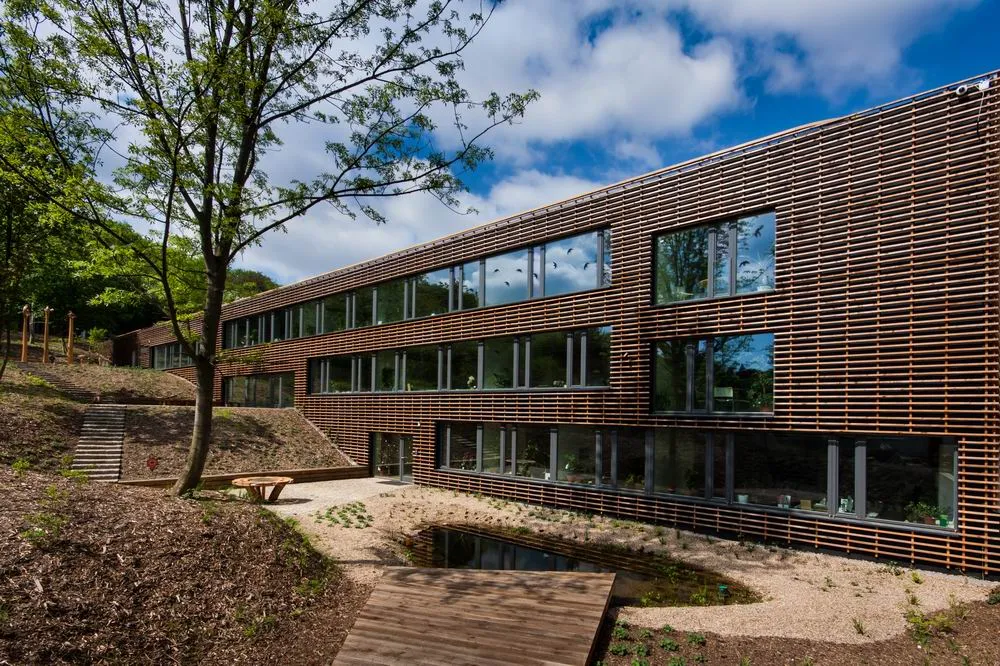 Dřevěná fasáda moderní budovy v přírodním prostředí.